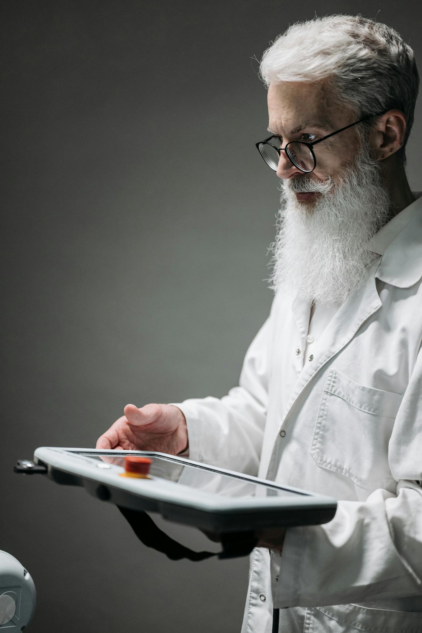 Scientist in lab coat using modern robotic control device for research.